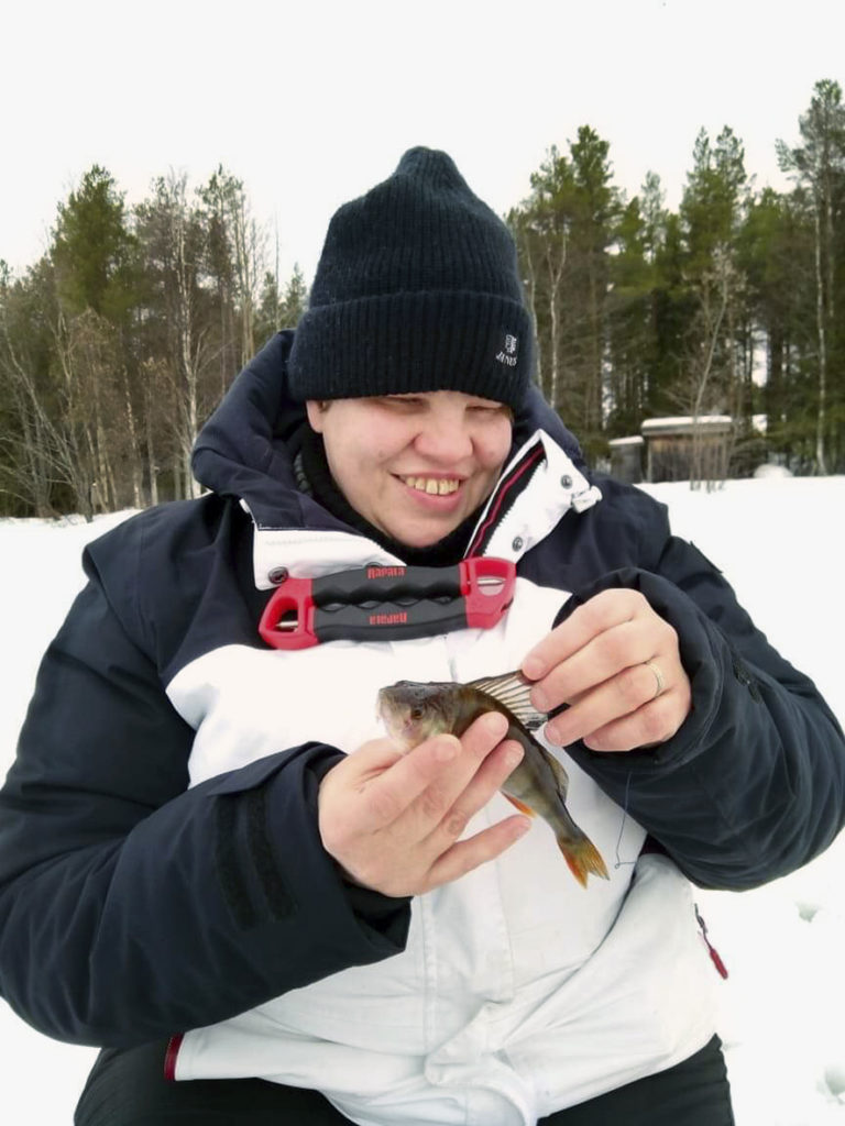 No tulihan sitä kalaa sittenkin -vaikkakin Sirpan pilkillä. Heidi tutkimassa pikkuisen ahvenen selkäevää hymy huulillaan. 