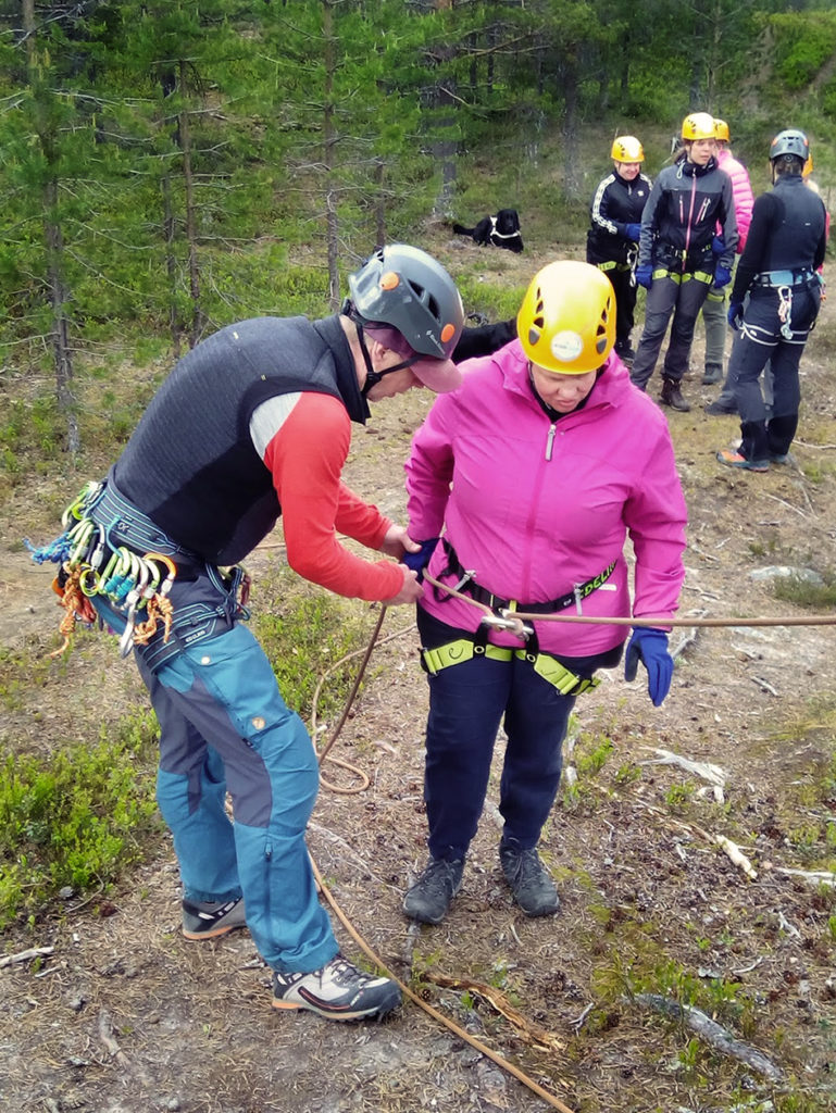 Jussi Tupasela kiinnittää laskeutumiseen tarvittavia köysiä Heidin vyötäisillä olevaan kiipeilyvyöhön. 